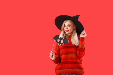 Beautiful young witch on color background. Halloween celebration