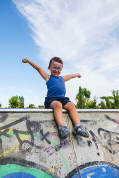 Happy Toddler Boy Sitting on an Half-pipe for Skaters