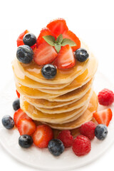Tower of pancakes with strawberries and honey