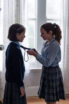 big sister helping with school uniform tie