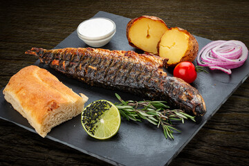 Grilled mackerel with baked potatoes, matnakash and red sauce. Served on a stone plate