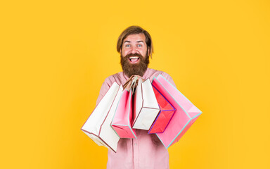 In shopping store. best sale offer. happy bearded man with present pack. cheerful brutal hipster hold gift. paper shopping bag. birthday surprise at party. man with package. prepare for holidays