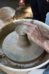 Master potter using a potter's wheel creates a vase from clay