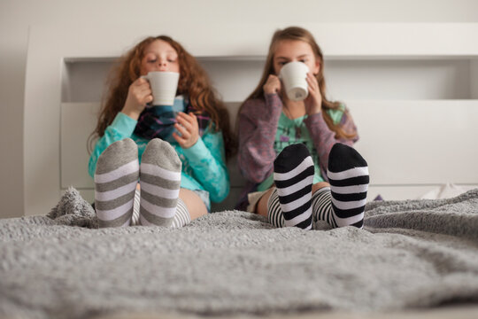 Friends having hot chocolate on a bed