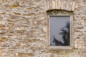 Fototapeta na wymiar Wooden window in an old stone barn