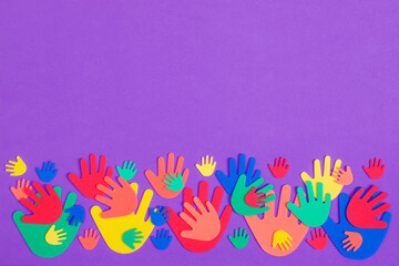 Fototapeta na wymiar Colorful red, orange, yellow, green and blue foam hands of different sizes on a plain purple background