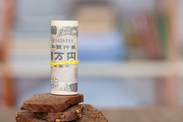 Japanese yen banknotes and black bread