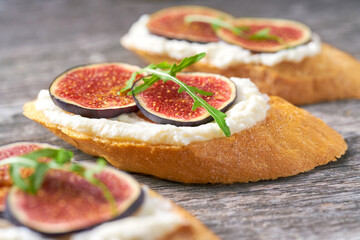 Bruschetta with ricotta cheese, ripe figs and honey close-up