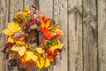Naklejka na ściany i meble Bright Autumn Wreath On A Wooden Background