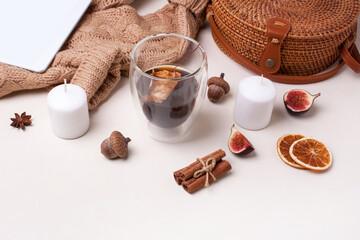 Autumn leaves, figs, dried orange, candles, notepad and coffee on a white background