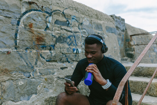 Young Athlete Taking A Rest Checking his Phone