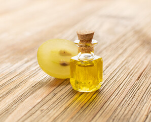 Grape Oil Seed in Small Vintage Bottle on Wooden Rustic Background