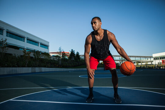 African American man playing basketball on an outdoor court