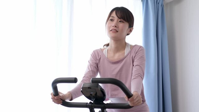 エアロバイクをこぐ女性