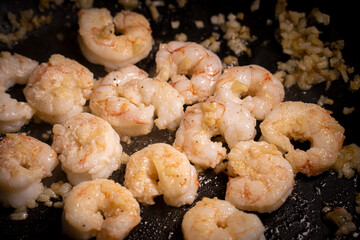 Prawns home cooking. Garlic and oil on a pan. Recipe close-up.