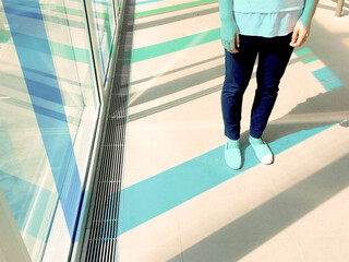 A woman's legs stands in blue stripe of light