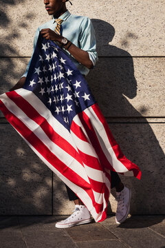 Afro businessman with american flag on copyspace wall