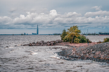 Windy rocky shore of the Bay with rolling waves and wind.