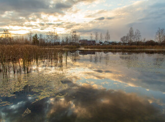 Fototapeta premium Clouds in the sky with reflection in the lake at sunset.