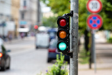 traffic control semaphore with green light on a defocused city background