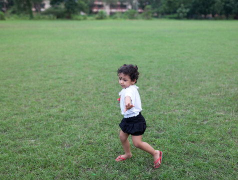Energetic kid streatching hands and making fun at outdoor
