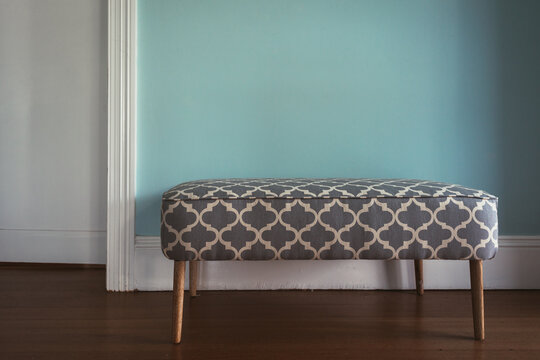 modern ottoman bench against a blue , with a moroccan ikat style fabric