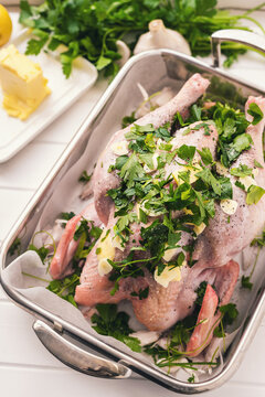 overhead view of a raw chicken prepared for roasting, with lemon