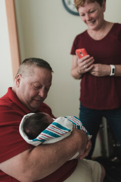 Proud grandparents holding his newborn grandson at the hospital