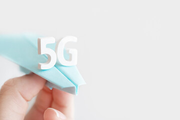 Flying paper plane with large white letters 5 G on gray background. Creative concept. Modern wireless high speed mobile internet. Connection technology for cell, laptop, phone. Use at home, work