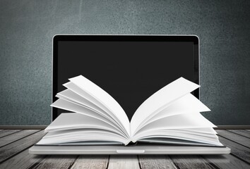 Open book and laptop screen. Education concept