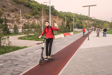 A young man chooses not public transport, but a personal or rented electric scooter to get to work quickly and safely