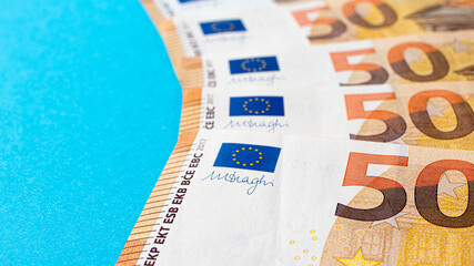 Fragment of the 50 fifty euro banknote on a blue background. Close up currency money with place for text copy space.
