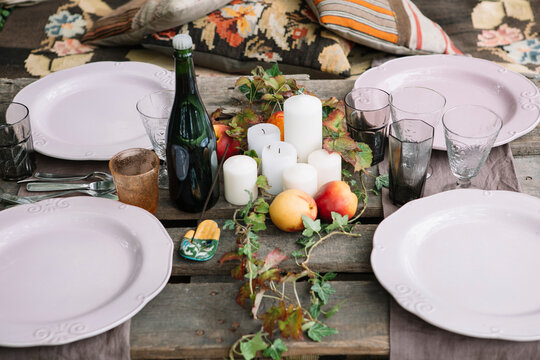 Served picnic table with kitchenware,drink and fruit