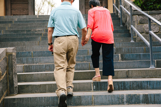 Couple holding hands walking up stairs