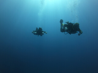 Buceadores de buceo técnico realizando ejercicios bajo el mar