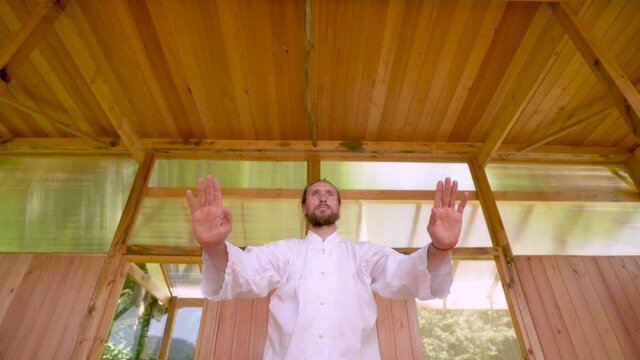 Close-up Bearded caucasian man wearing white clothes to practice concentration and breathing before practicing qigong tai chi