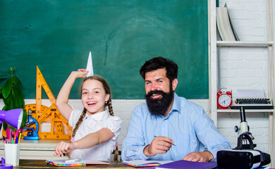 happy day. small girl child with bearded teacher man in classroom. private lesson. daughter study...