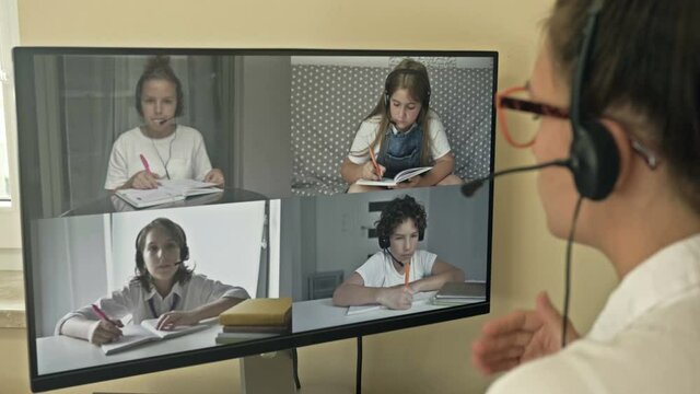 Teacher leads a video lesson for four students. Features of distance learning. Back to school.