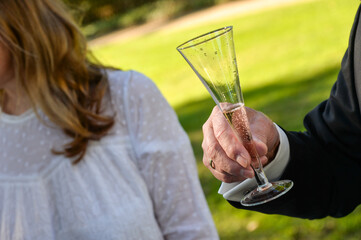 hand hält sektglas anstoßen sektempfang prosit neujahr outdoor hochzeit