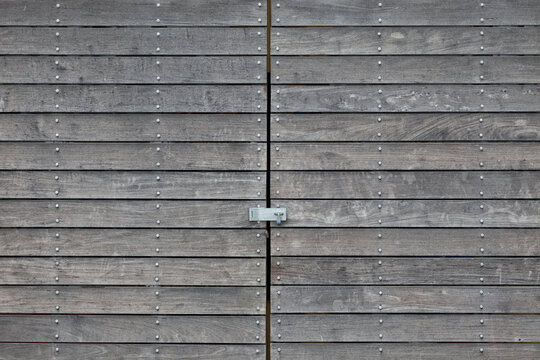 Weathered wood doors, with a padlock, on a storage building