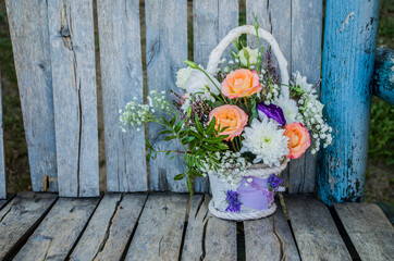 Bouquet of orange roses and chrysanthemums on a shabby wooden background.