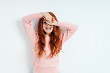 Vivacious laughing young redhead woman on white