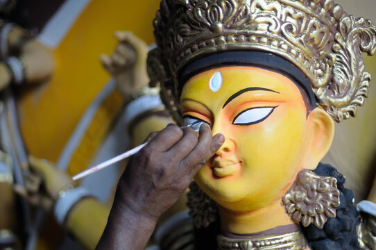 Artist painting the eye of idol of Hindu goddess Durga