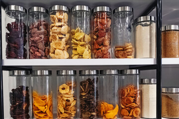 Shelves with glass jars with dry fruits