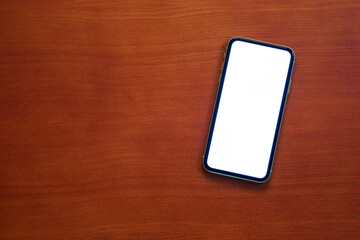 Touch screen mobile phone on brown table background.