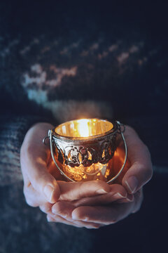 Woman Holding A Votive Candle In Her Hands