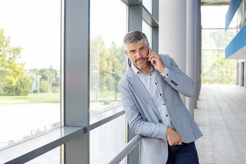 Businessman talking on mobile phone in front of an office