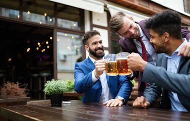 Group of happy friends drinking beer at the pub and having fun