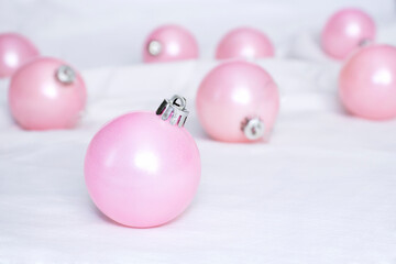 pink Christmas tree balls bauble on white cloth. Christmas minimal concept selective focus.