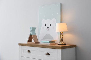 Modern white chest of drawers near light wall in child room. Interior design